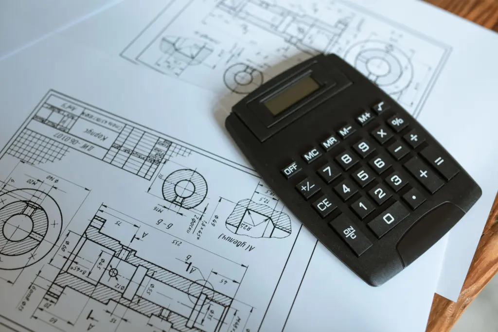 A calculator on technical drawings used to estimate an ICF wall construction budget.